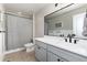 Modern bathroom with gray vanity, white countertop, a large mirror, and a shower with a striped curtain at 110 Ferris Ln, Erie, CO 80516