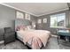 Cozy bedroom featuring soft, pink accents, gray walls and carpet, and a large bed with plush bedding at 110 Ferris Ln, Erie, CO 80516