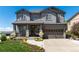 Charming gray two-story home with stone accents, a welcoming front porch and manicured lawn at 110 Ferris Ln, Erie, CO 80516