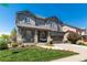 Inviting two-story gray home with a charming front porch, stone accents, and a well-maintained lawn at 110 Ferris Ln, Erie, CO 80516