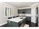 Kitchen features stainless steel appliances, large island, and sleek green cabinetry at 110 Ferris Ln, Erie, CO 80516