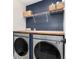 Functional laundry area with modern Samsung washer and dryer under a butcher block countertop and blue accent wall at 110 Ferris Ln, Erie, CO 80516