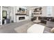 Inviting living room featuring a stone fireplace, floating shelves, and a comfortable gray sectional sofa at 110 Ferris Ln, Erie, CO 80516