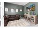 Comfortable living room with a tufted leather couch, entertainment center, and scenic mountain view on TV at 110 Ferris Ln, Erie, CO 80516