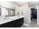 Bright bathroom with double sinks, modern fixtures, large mirror, and access to a walk-in closet at 110 Ferris Ln, Erie, CO 80516