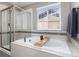 Relaxing bathroom featuring a soaking tub, separate shower, and elegant tilework at 110 Ferris Ln, Erie, CO 80516