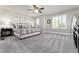 Spacious main bedroom with neutral colors, large bed, ceiling fan, and bright, shuttered windows at 110 Ferris Ln, Erie, CO 80516