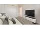 This staged bedroom features a large closet, a television, and a place to rest at 12010 E Harvard Ave, Aurora, CO 80014