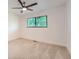 Sunny bedroom with a ceiling fan and window offering a view of lush greenery at 12010 E Harvard Ave, Aurora, CO 80014