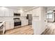Bright, modern kitchen featuring white cabinets, stainless steel appliances, and durable countertops at 12010 E Harvard Ave, Aurora, CO 80014