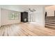 Open living room with modern flooring, a stone fireplace, and a staircase leading upstairs at 12010 E Harvard Ave, Aurora, CO 80014