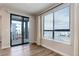 View of large windows and sliding glass doors to outdoor balcony from bright, neutrally decorated living room at 1990 S Holly St # 4, Denver, CO 80222