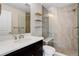 Modern bathroom featuring tiled shower, floating shelves, and vanity with sink at 1990 S Holly St # 4, Denver, CO 80222