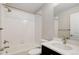 Well-lit bathroom features white tile, a shower-tub combo, and a vanity with a stylish faucet at 1990 S Holly St # 4, Denver, CO 80222