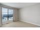 Bedroom with neutral walls, carpet, and large window providing natural light at 1990 S Holly St # 4, Denver, CO 80222