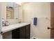 Neat bathroom featuring a dark vanity, neutral walls, and a mirrored medicine cabinet at 8060 W 9Th Ave # 204, Lakewood, CO 80214