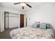 Bedroom features ceiling fan, closet, and bed with floral comforter, and soothing pillows at 8060 W 9Th Ave # 204, Lakewood, CO 80214