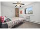 Bedroom with ceiling fan, brick accent wall, window, and bed with floral comforter at 8060 W 9Th Ave # 204, Lakewood, CO 80214