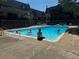 Community pool surrounded by buildings and people enjoying the water on a sunny day at 8060 W 9Th Ave # 204, Lakewood, CO 80214