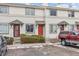 Townhouse exterior features neutral siding, colorful front doors, and manicured bushes, with a glimpse of winter landscape at 17694 E Loyola Dr # C, Aurora, CO 80013