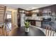 Well-lit kitchen with stainless steel appliances, dark cabinets, and a view of the staircase and living room at 17694 E Loyola Dr # C, Aurora, CO 80013