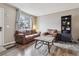 Cozy living room featuring comfortable leather furniture, a large window, and a decorative bookshelf at 17694 E Loyola Dr # C, Aurora, CO 80013