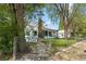 View of the front of a home, including the house number, surrounded by trees and a chainlink fence at 701 W Quincy Ave, Englewood, CO 80110