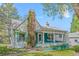 Charming two-story home with a brick chimney, a quaint covered porch, and white and blue trim at 701 W Quincy Ave, Englewood, CO 80110