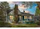 Charming two-story home with a brick chimney, a quaint covered porch, and white and blue trim at 701 W Quincy Ave, Englewood, CO 80110