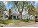 Charming home with a brick chimney, a fenced yard, and a detached garage in the backyard at 701 W Quincy Ave, Englewood, CO 80110