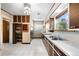 Well-lit kitchen featuring tiled floor, wood cabinets, and modern appliances at 701 W Quincy Ave, Englewood, CO 80110