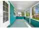 Covered porch with blue painted wood, white columns, and a view of the yard at 701 W Quincy Ave, Englewood, CO 80110