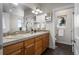 Bright bathroom featuring double sinks, wood cabinets, tile countertops, and a separate toilet room at 1505 Legacy Trl, Elizabeth, CO 80107