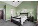 Calm bedroom features a high ceiling, a plush bed, and a serene green color scheme at 1505 Legacy Trl, Elizabeth, CO 80107