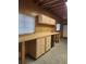Garage workbench featuring a pegboard backsplash, storage cabinets, and multiple windows for natural lighting at 1505 Legacy Trl, Elizabeth, CO 80107