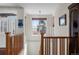 Hallway with wood banister, chandelier, and a large window that offers lots of natural light at 1505 Legacy Trl, Elizabeth, CO 80107