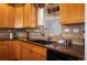 Charming kitchen features warm wood cabinetry, granite countertops, and a stainless steel faucet at 1505 Legacy Trl, Elizabeth, CO 80107