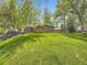 Backyard with lush green lawn surrounded by mature trees provides a serene setting at 1720 S Ammons St # A, Lakewood, CO 80232