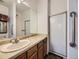 Bathroom featuring a large mirror, vanity with marble countertop, and glass-enclosed shower at 1720 S Ammons St # A, Lakewood, CO 80232