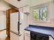 Traditional kitchen features white appliances, wood cabinets, blue countertop, and natural light at 1720 S Ammons St # A, Lakewood, CO 80232