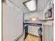 Compact kitchen featuring white cabinets, blue countertops, and modern appliances at 1720 S Ammons St # A, Lakewood, CO 80232