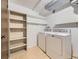 Well-equipped laundry room with a washer, dryer, shelving, and wood-look flooring at 1720 S Ammons St # A, Lakewood, CO 80232