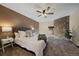 Comfortable bedroom featuring a stone accent wall, ceiling fan and plush carpeting at 1731 S Blackhawk Way # A, Aurora, CO 80012