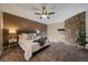 Comfortable bedroom featuring a stone accent wall, ceiling fan and plush carpeting at 1731 S Blackhawk Way # A, Aurora, CO 80012