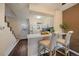 Well-lit kitchen with breakfast bar, white cabinets, and easy access to stairs and back door at 1731 S Blackhawk Way # A, Aurora, CO 80012