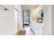 Bright bathroom with double vanity leading into the bedroom and a glass shower enclosure at 15402 E 113Th Pl, Commerce City, CO 80022