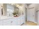Elegant bathroom with double vanity, framed mirror, and modern lighting fixtures at 15402 E 113Th Pl, Commerce City, CO 80022