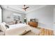 Serene bedroom featuring a ceiling fan, wood floors, and a mid-century modern dresser at 15402 E 113Th Pl, Commerce City, CO 80022