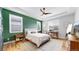 Stylish bedroom with a green accent wall, a ceiling fan, and lots of natural light at 15402 E 113Th Pl, Commerce City, CO 80022