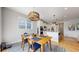 Dining space open to kitchen featuring natural light and modern light fixture at 15402 E 113Th Pl, Commerce City, CO 80022